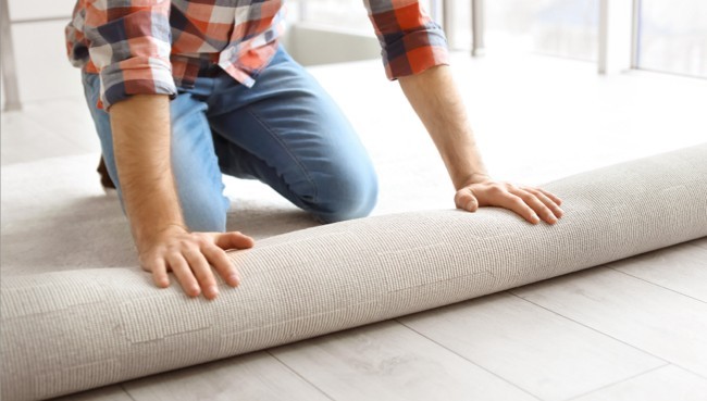 Man rolling carpet for installation | CarpetsPlus Of Wisconsin